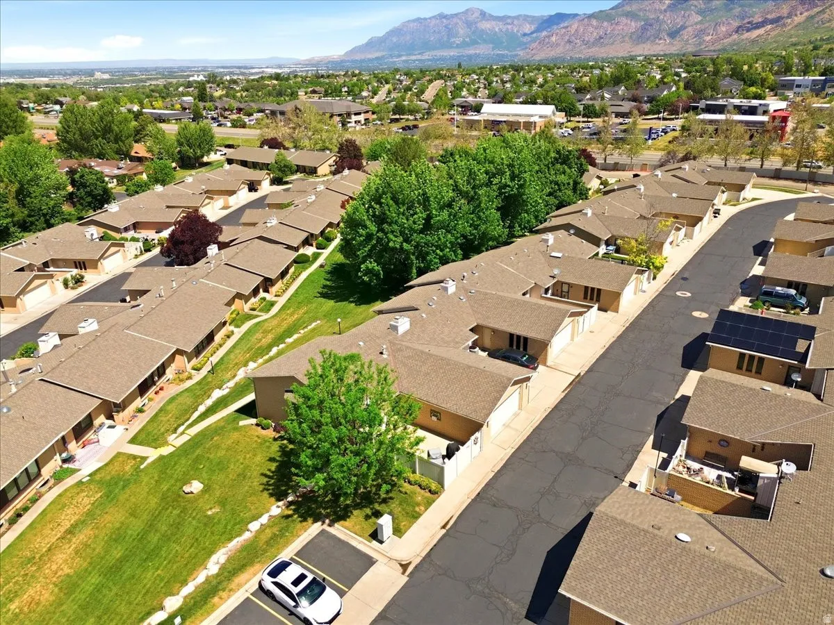 Residential community featuring single-story properties with attached garages and brown shingle roofing