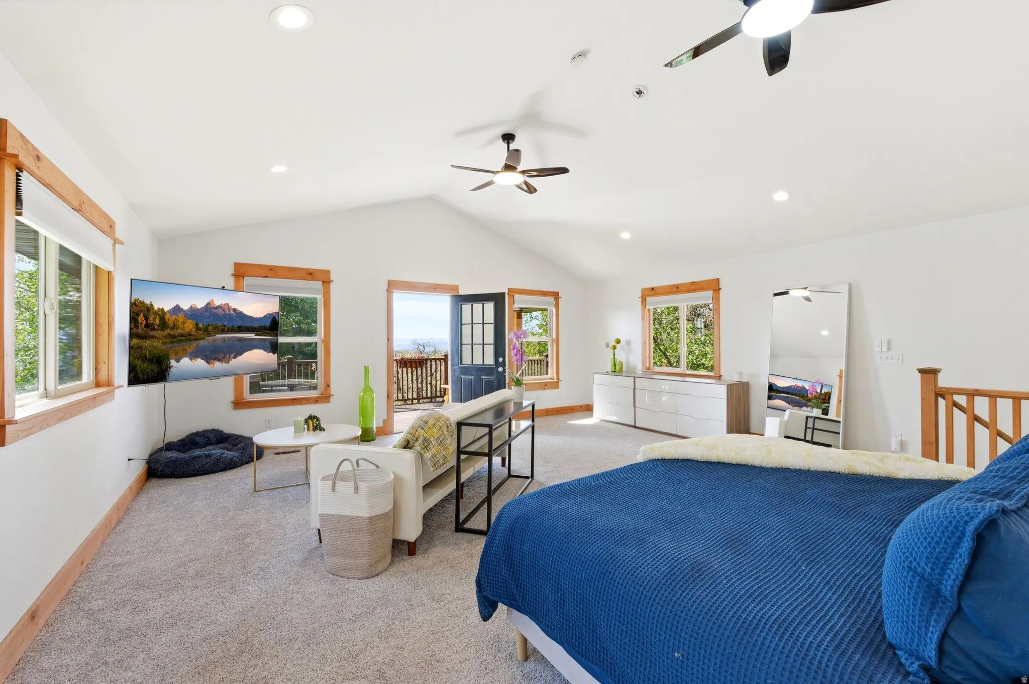 Spacious room featuring vaulted ceilings with recessed lighting and ceiling fans