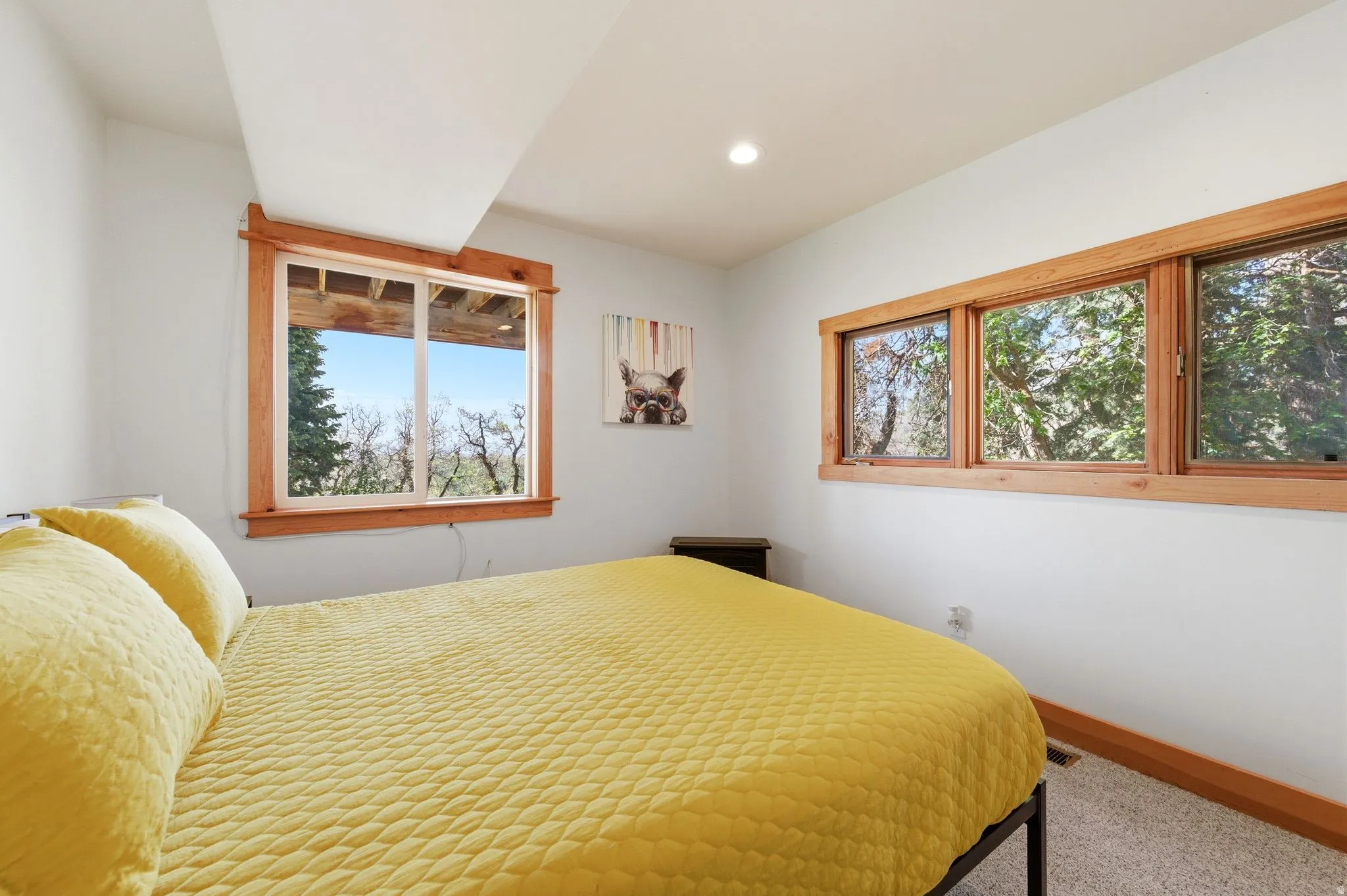 Bright interior space featuring light-colored walls, wood-trimmed windows, and recessed lighting