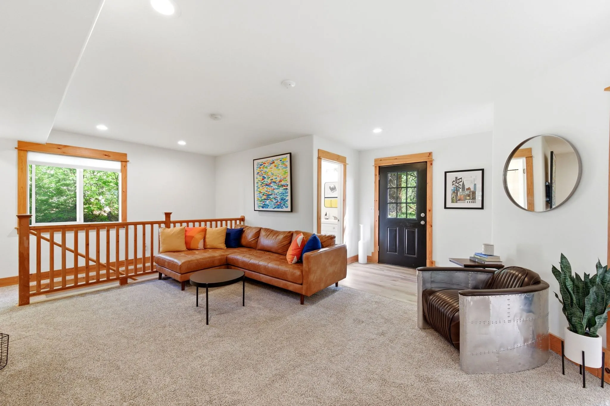 Spacious bonus room featuring light-toned carpet, recessed lighting, and a window with natural wood trim