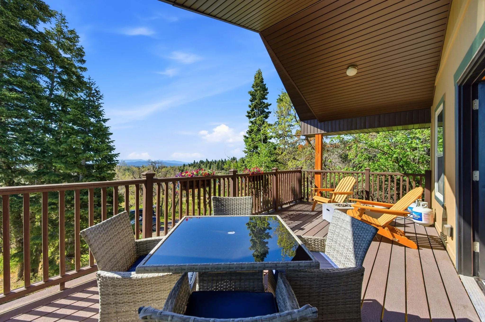 Spacious outdoor deck featuring wood-finish flooring, a full-height wood railing, and a slatted wood ceiling