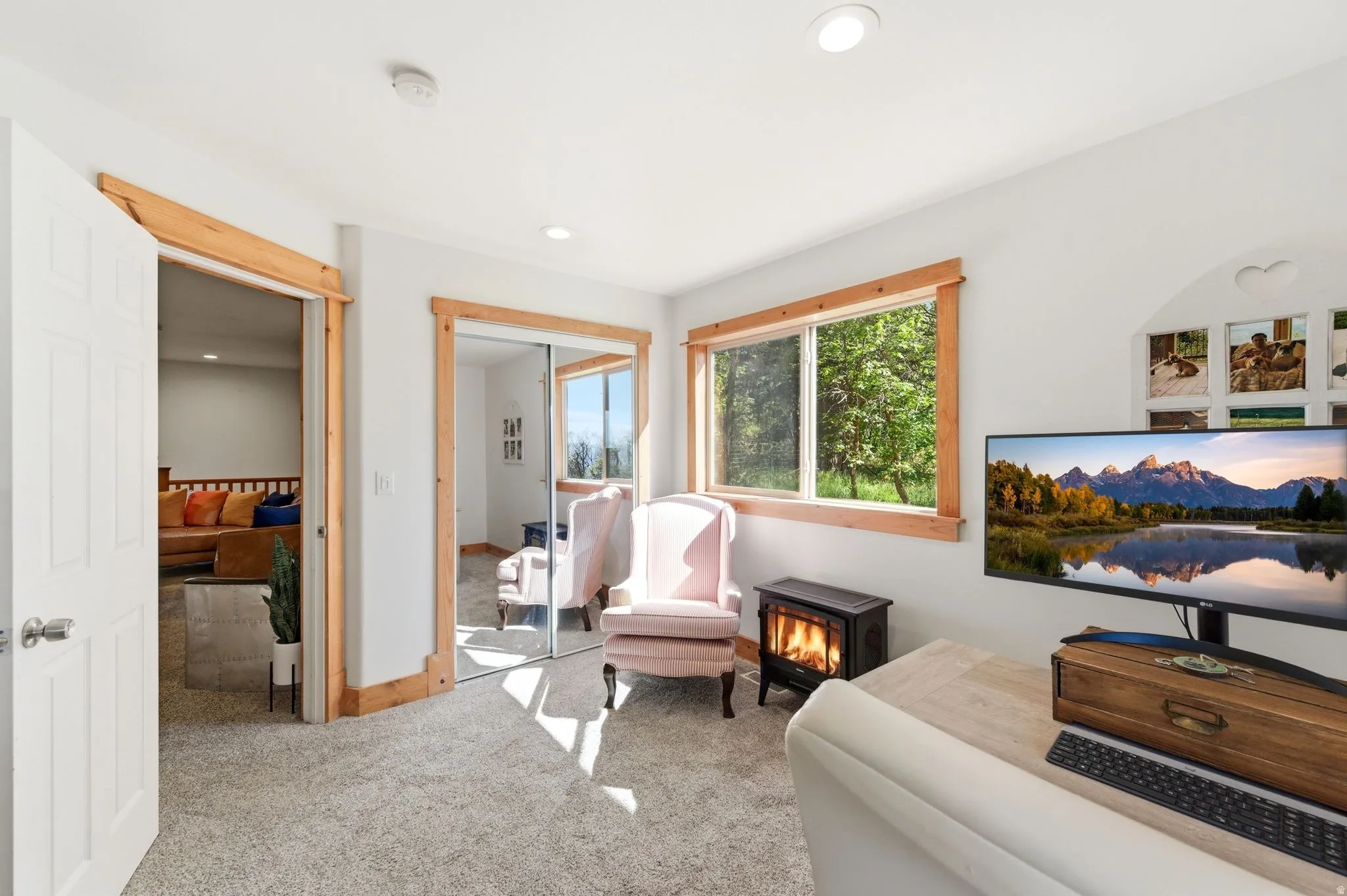 Carpeted interior space featuring white walls and natural wood trim accents