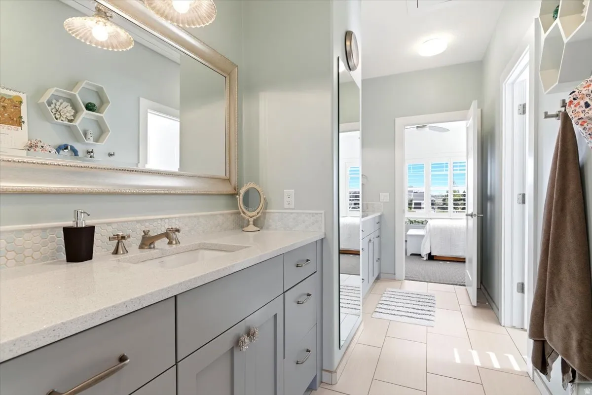 Vanity featuring an integrated sink, light-toned countertop, and a tiled backsplash