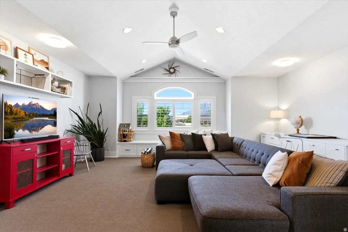 Vaulted ceiling with recessed lighting and a ceiling fan
