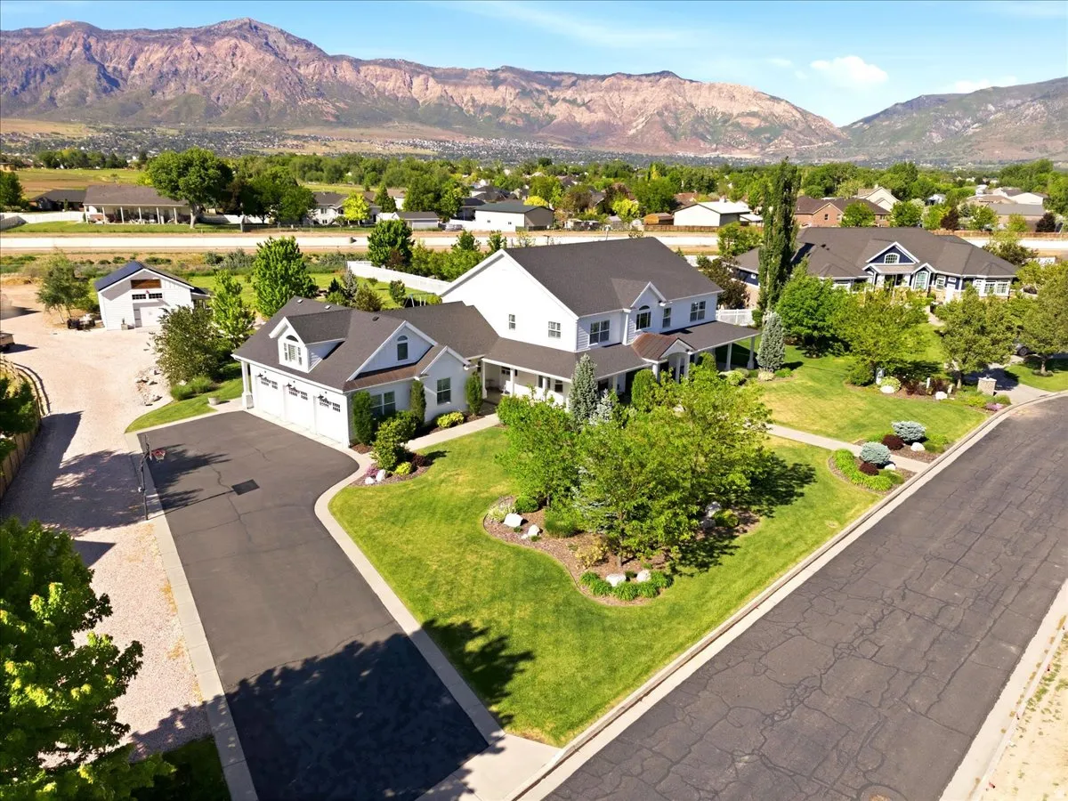 Expansive property featuring a two-story residence with a covered porch and an attached three-car garage
