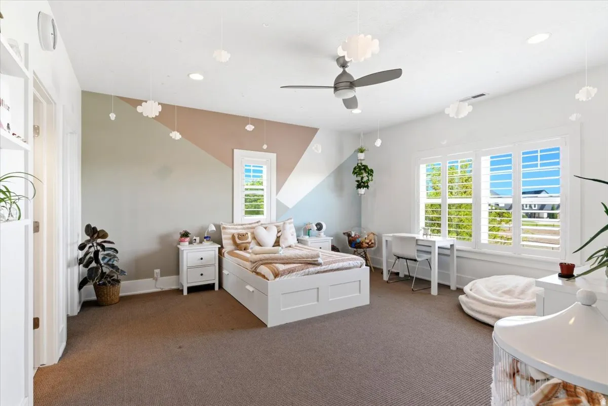 Spacious room featuring broadloom carpeting and a ceiling fan