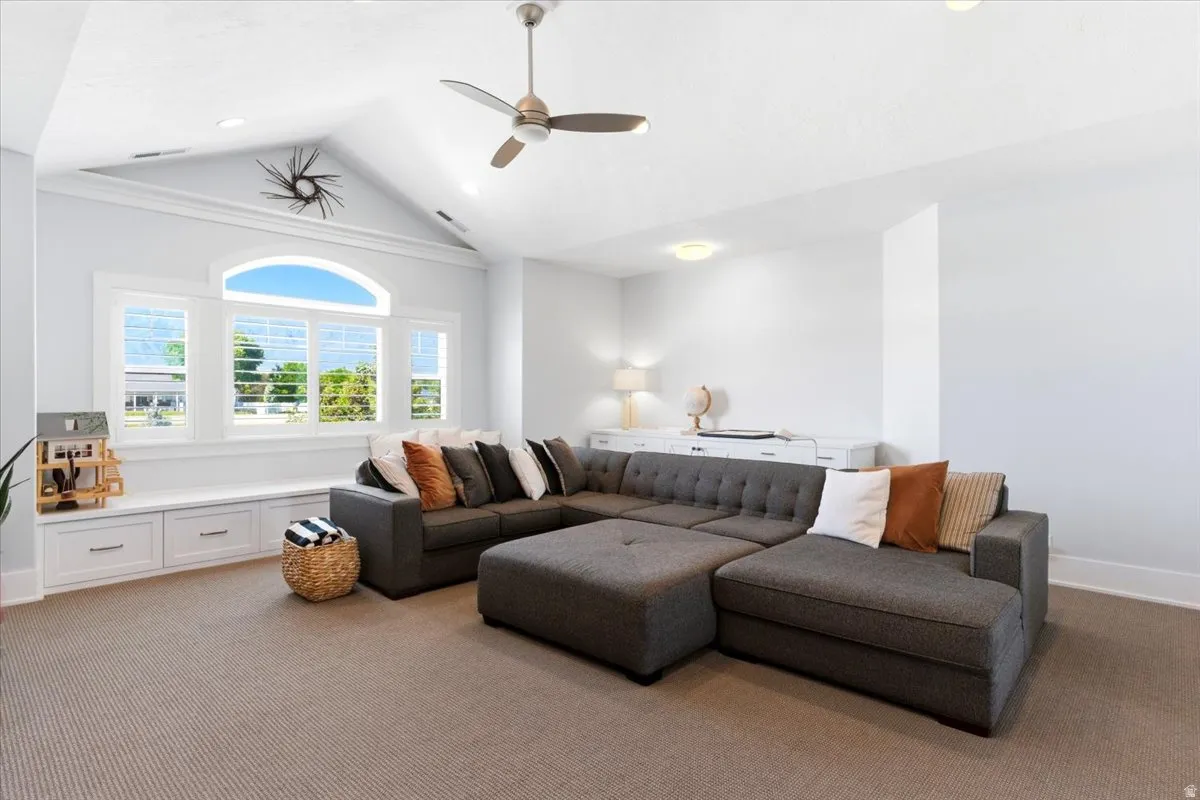 Vaulted ceiling with an overhead fan and recessed lighting