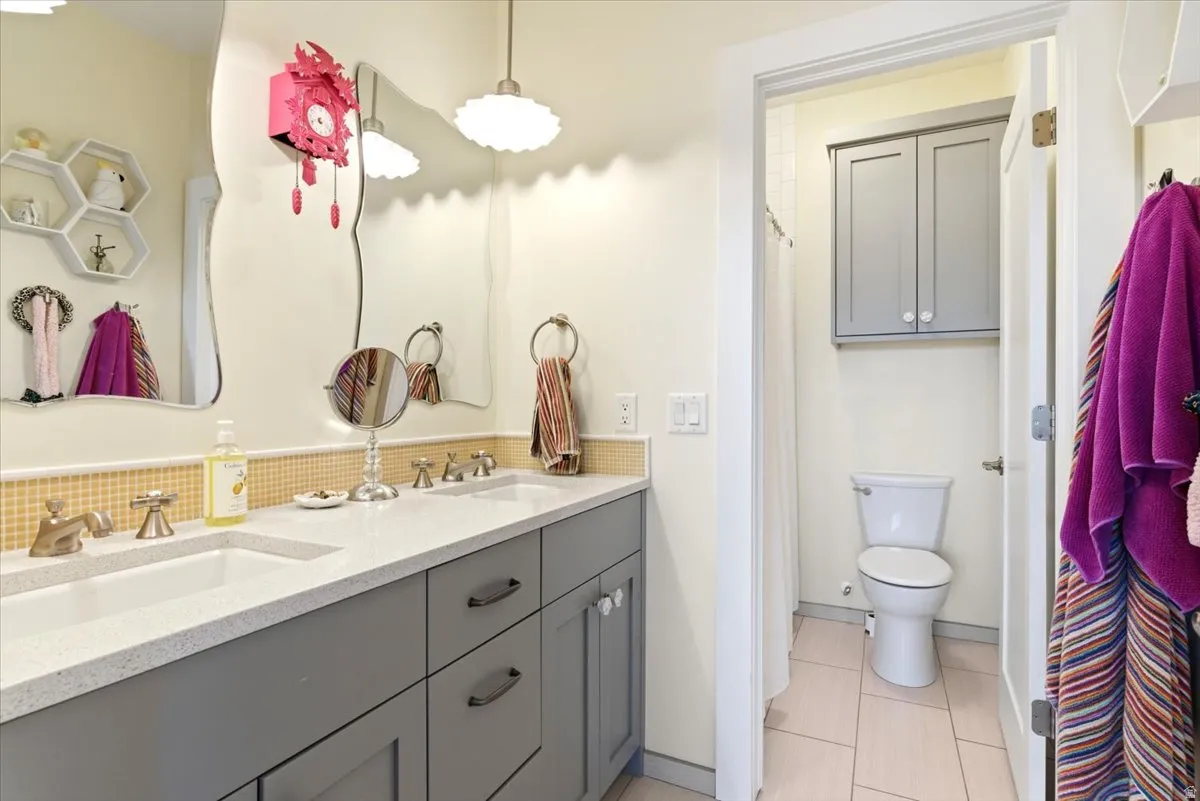 Dual vanity featuring integrated sinks and a light-toned countertop, set atop gray cabinetry