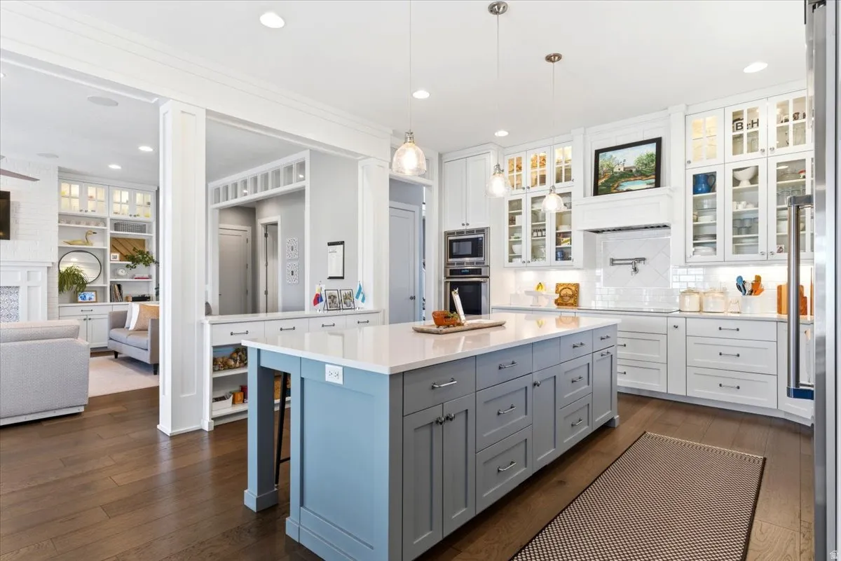 Spacious kitchen featuring a large central island with light blue and gray cabinetry, light countertops, and pendant lighting