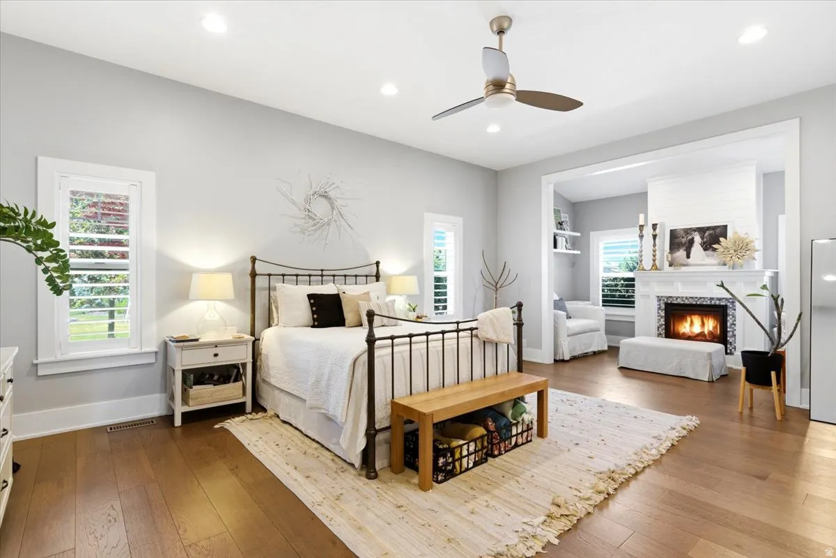 Hardwood flooring throughout featuring a ceiling fan, recessed lighting, and white plantation shutters on windows