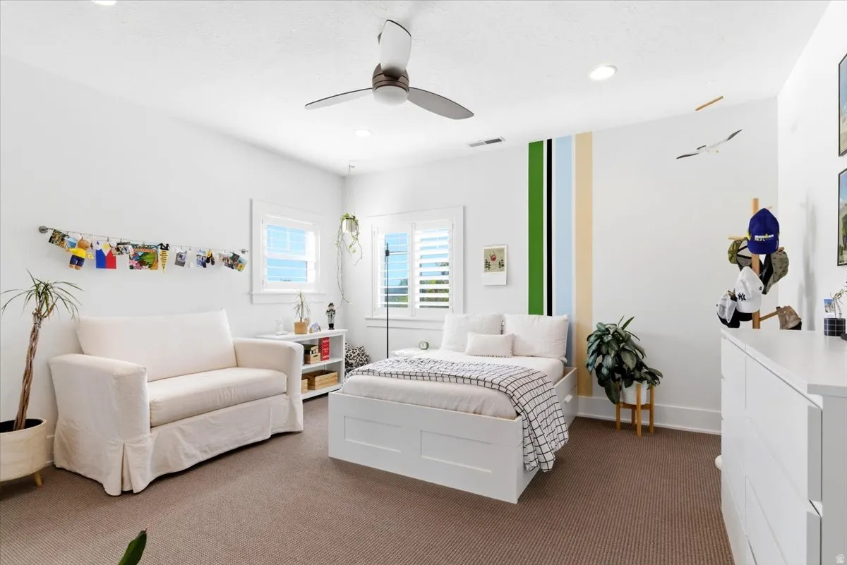 Bright interior space featuring white walls and a ceiling fan with integrated lighting