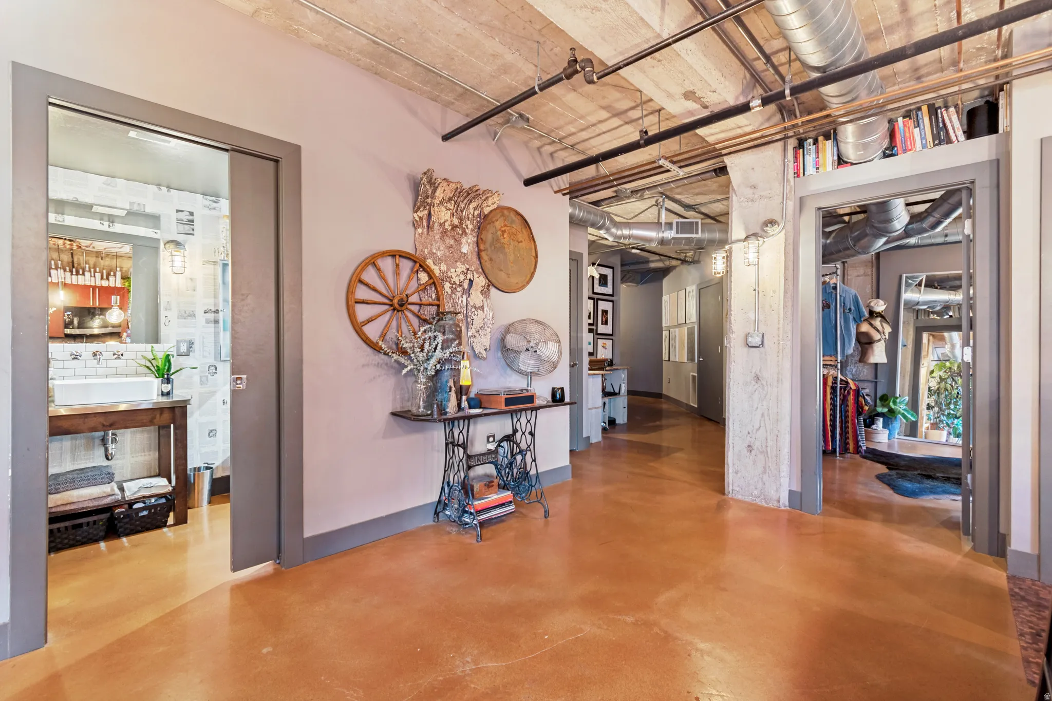 Polished concrete flooring extending through the hallway, exposed concrete ceiling, and visible ductwork
