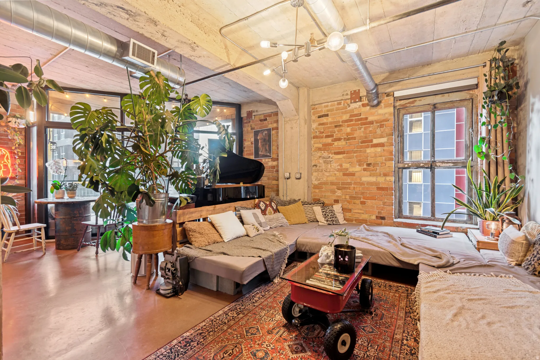 Exposed brick walls, concrete ceilings, and visible ductwork define this loft-style interior