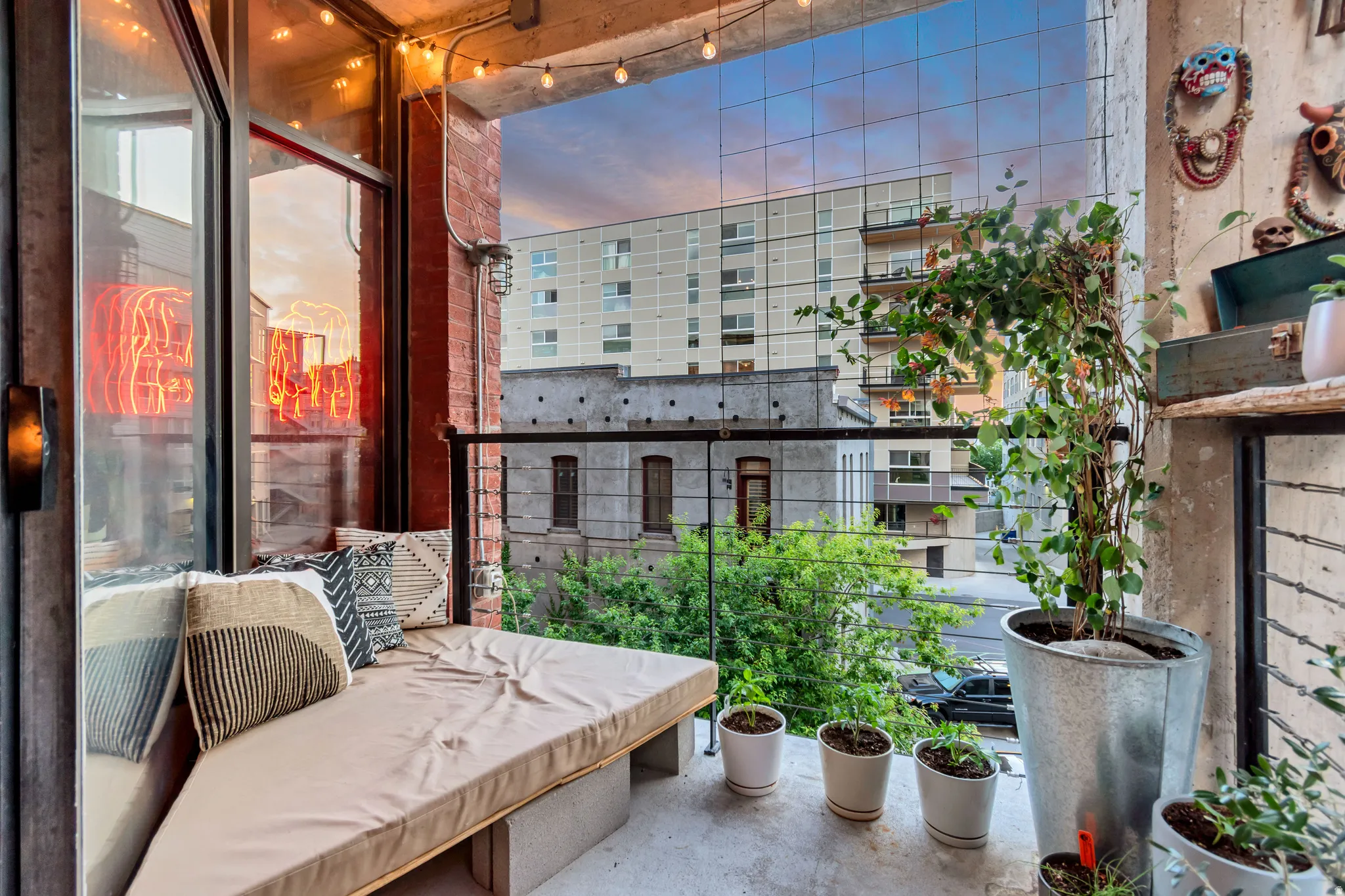 Private outdoor balcony space featuring a concrete floor, red brick wall accents, and an integrated bench seating area
