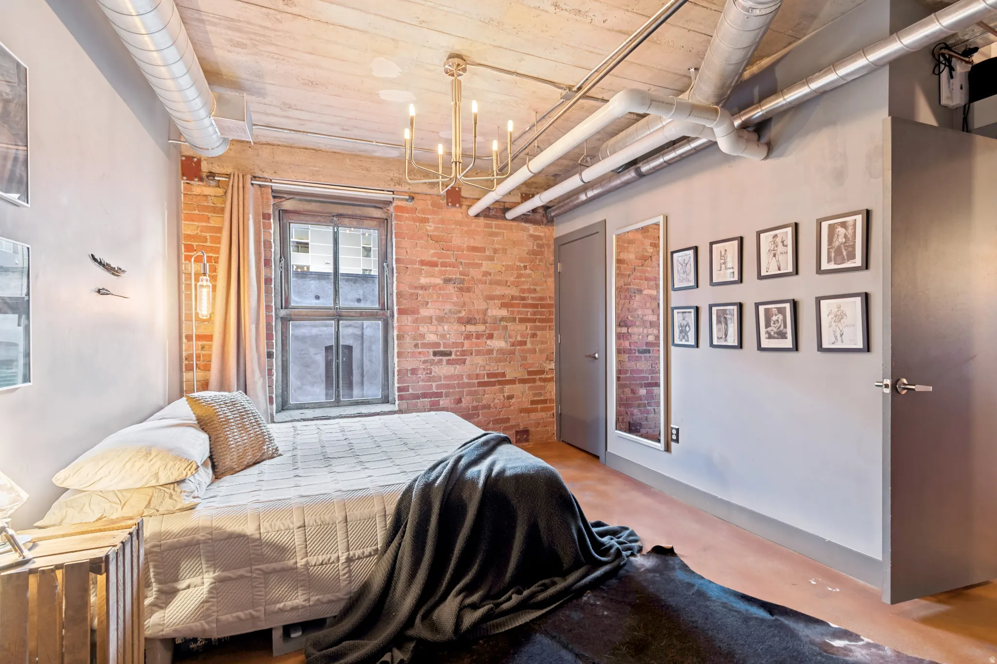 Exposed brick accent wall with a window featuring dark framing