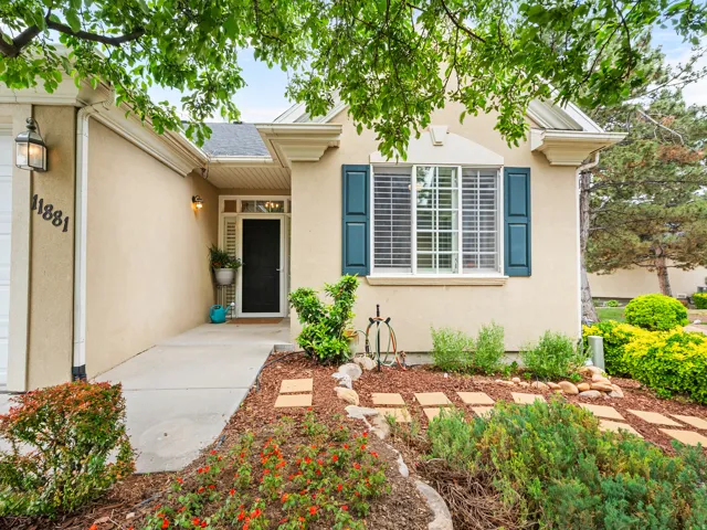 Stucco exterior with a dark entry door, transom window, and sidelight