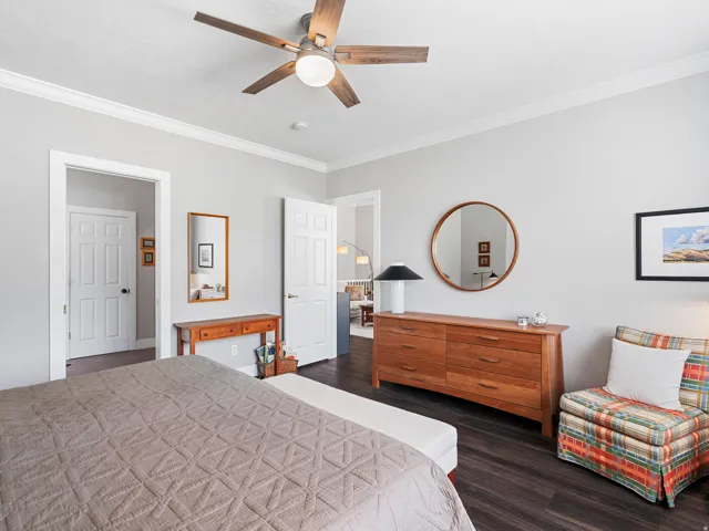 Interior space featuring dark wood-finish flooring, light grey walls, and white crown molding
