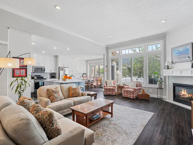 Open-concept living area featuring dark wood-finish flooring, recessed lighting, and crown molding