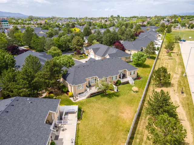 Aerial perspective showcasing multiple properties with dark shingle roofing