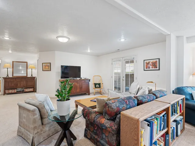 Spacious recreational room featuring recessed lighting, light-toned carpeting, and a double French door egress