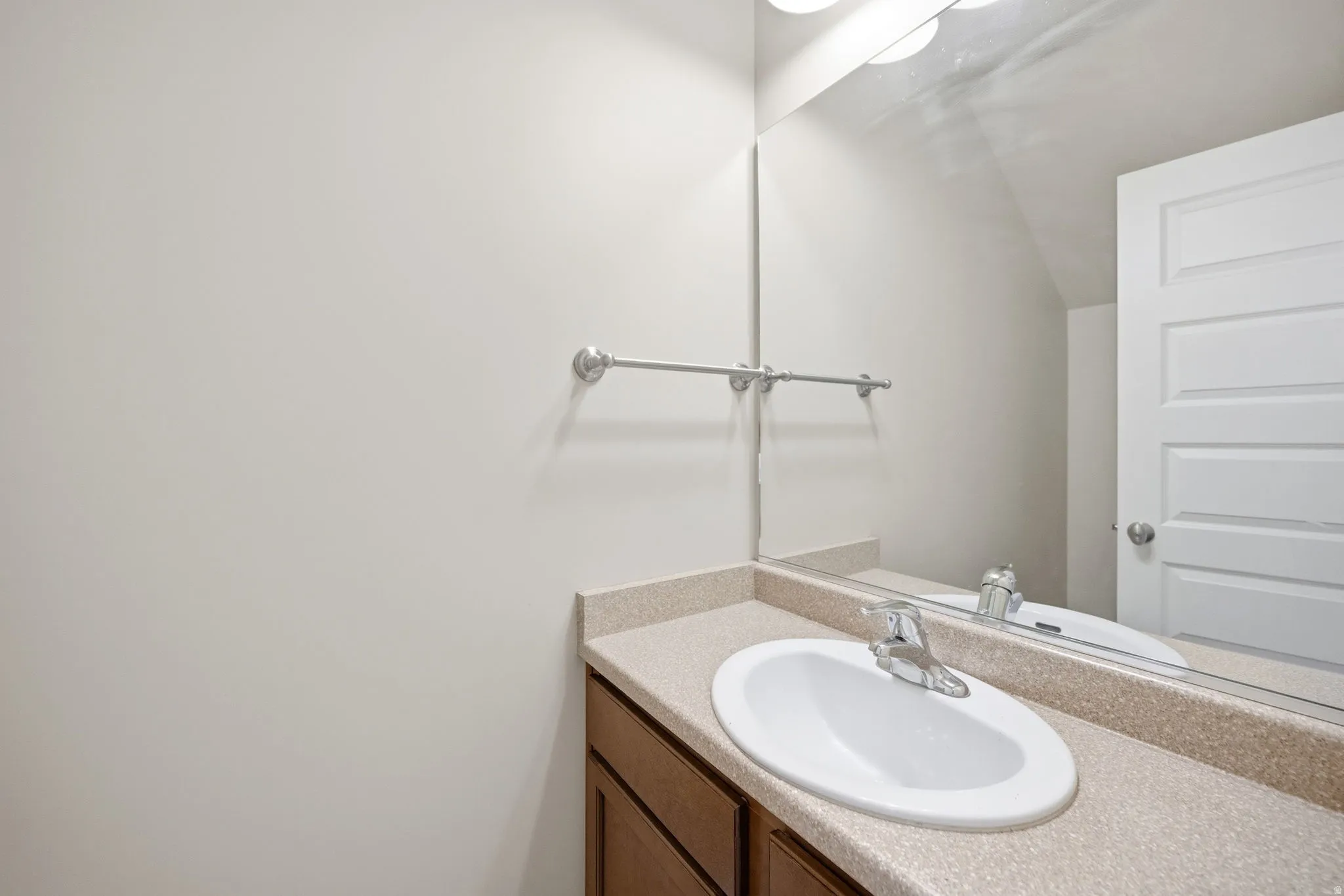 Bathroom vanity featuring an integrated sink, laminate countertop, and wood-finish cabinetry