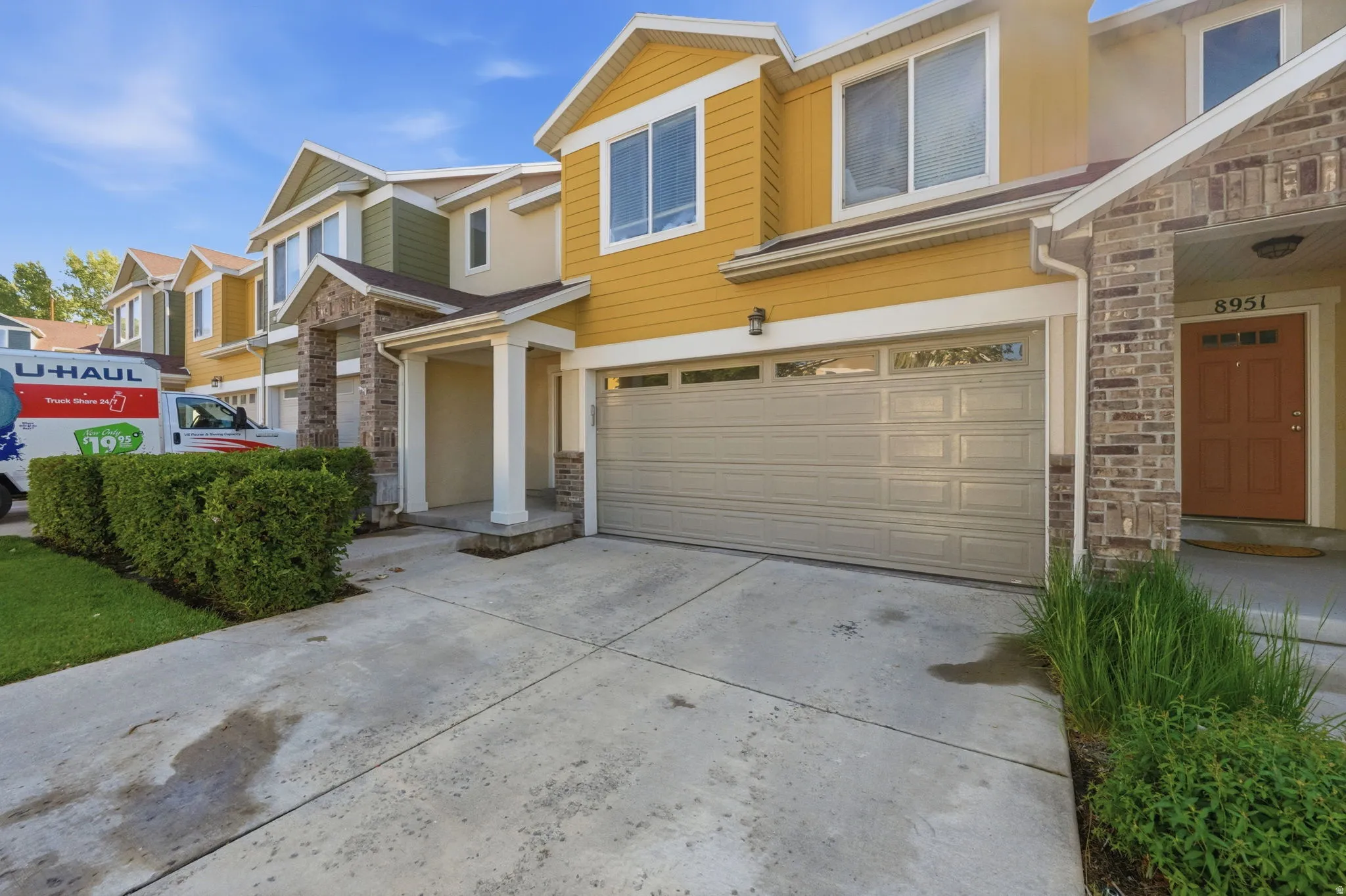 Exterior facade featuring yellow siding, stone accents, and a covered entry