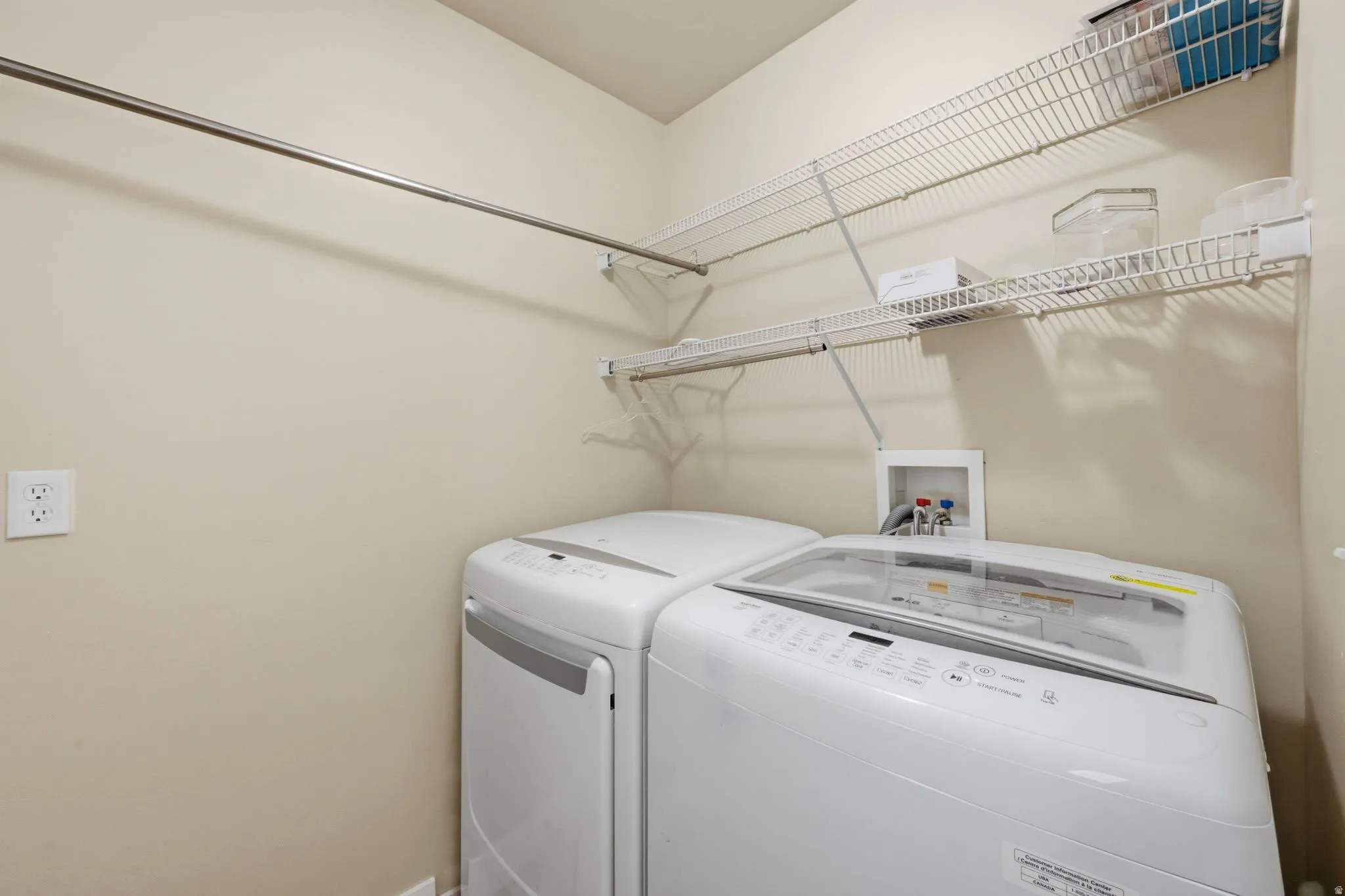 Dedicated laundry area featuring a top-load washing machine, wire shelving, and a clothing rod