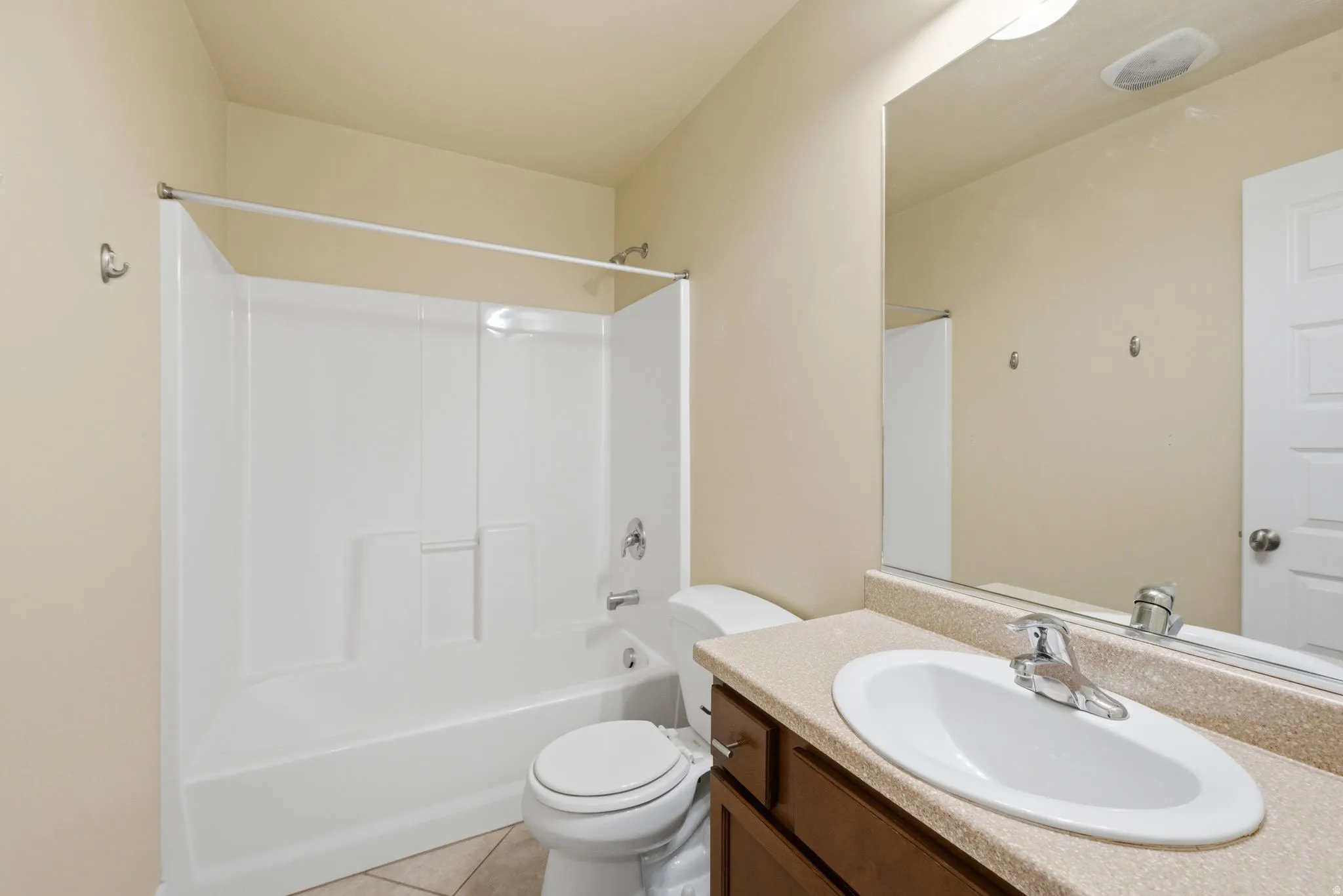 Bathroom featuring a white bathtub and shower surround with chrome fixtures