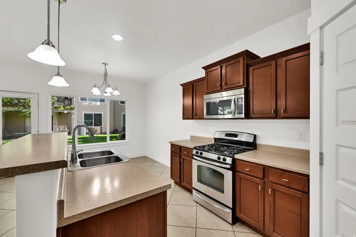 Stainless steel gas range, built-in microwave, and double basin sink