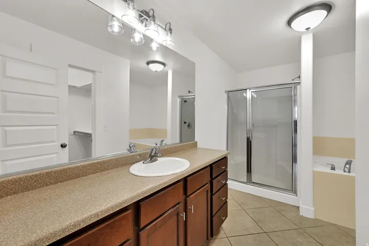 Bathroom with a long vanity, integrated sink, and a shower with a sliding glass enclosure