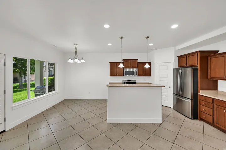 Kitchen with wood cabinetry, stainless steel appliances, and a breakfast bar