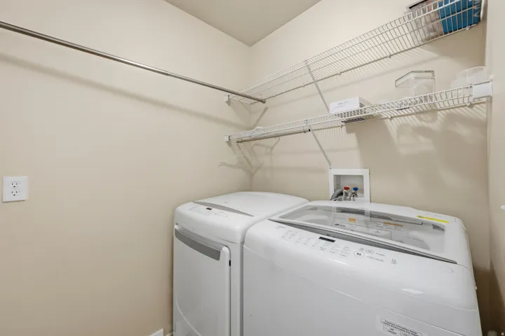 Dedicated laundry area featuring a top-load washing machine, wire shelving, and a clothing rod