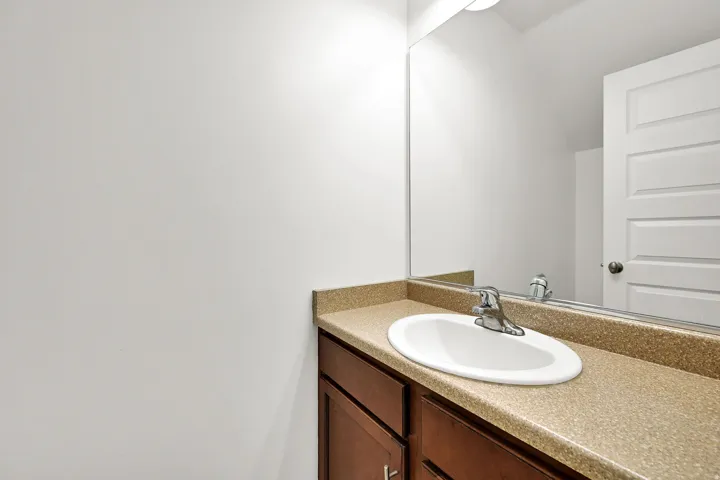 Integrated vanity with a white oval sink, chrome faucet, and spacious countertop