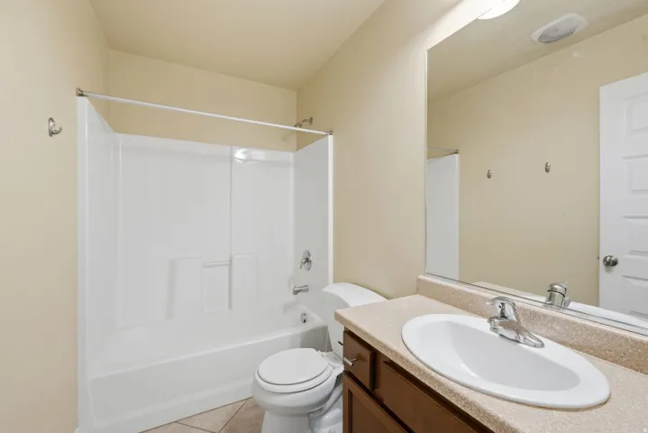 Bathroom featuring a white bathtub and shower surround with chrome fixtures