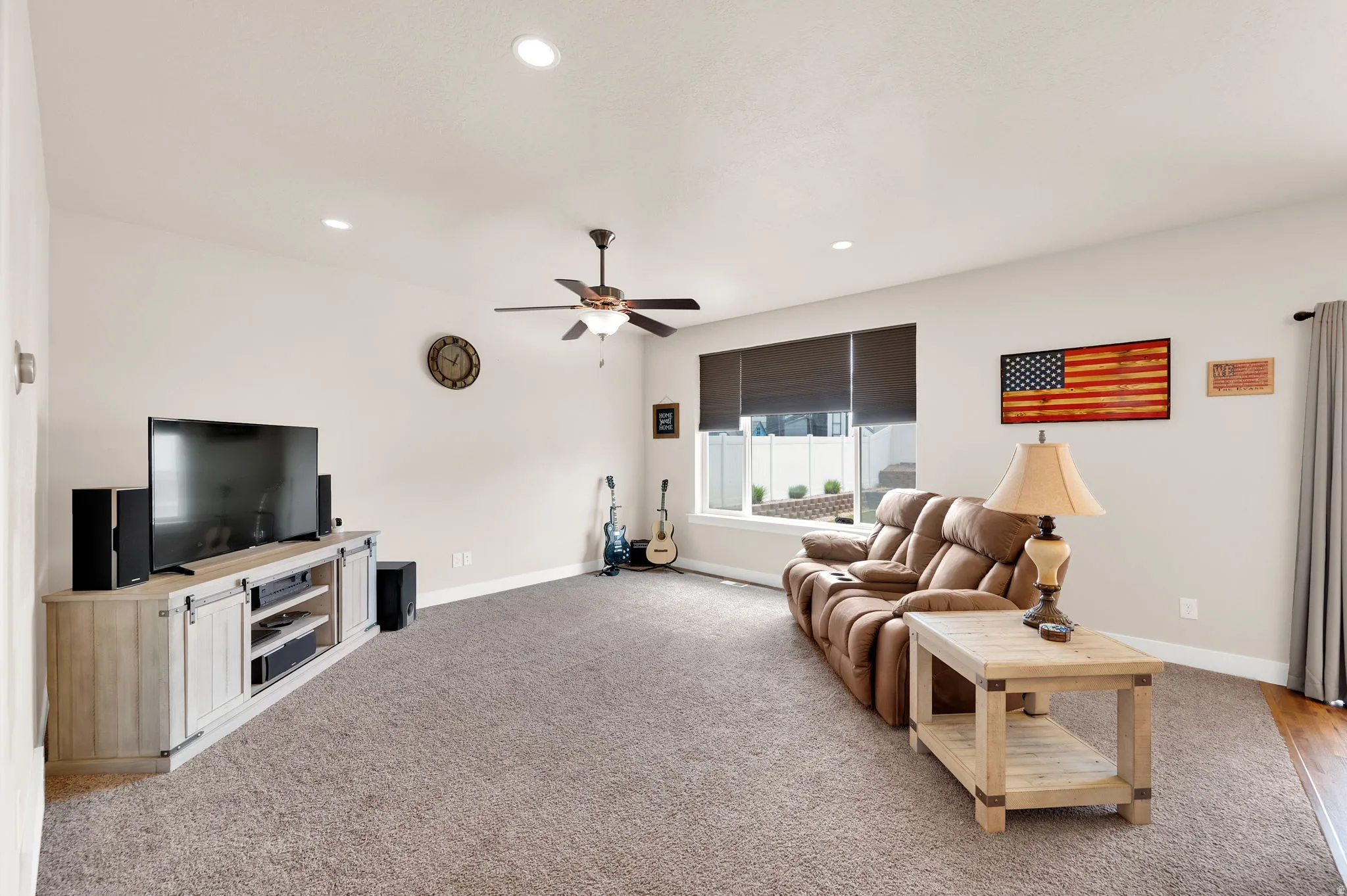 Spacious living area featuring neutral carpeting and light-colored walls