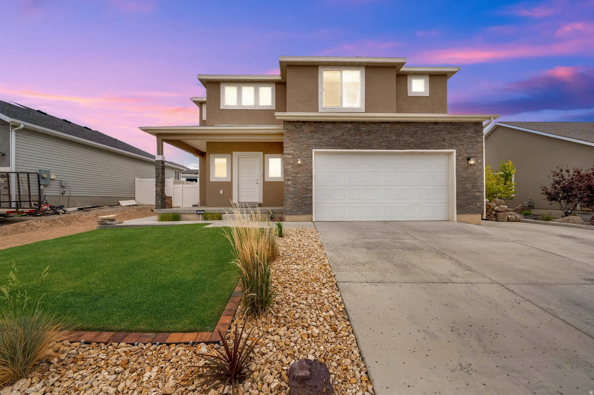 Contemporary two-story residence featuring a stone and stucco facade