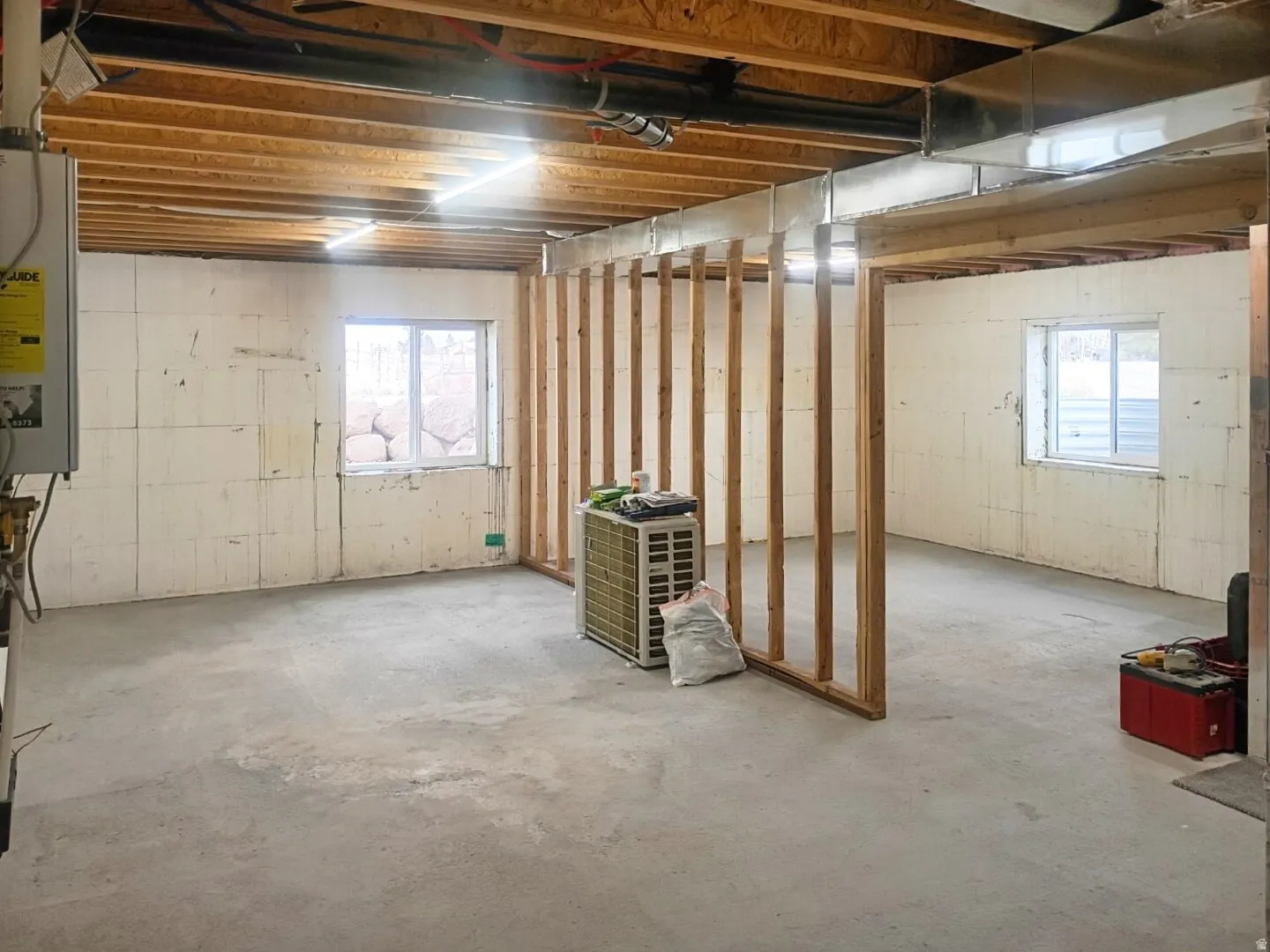Unfinished lower level featuring exposed ceiling joists, concrete flooring, and partial wall framing