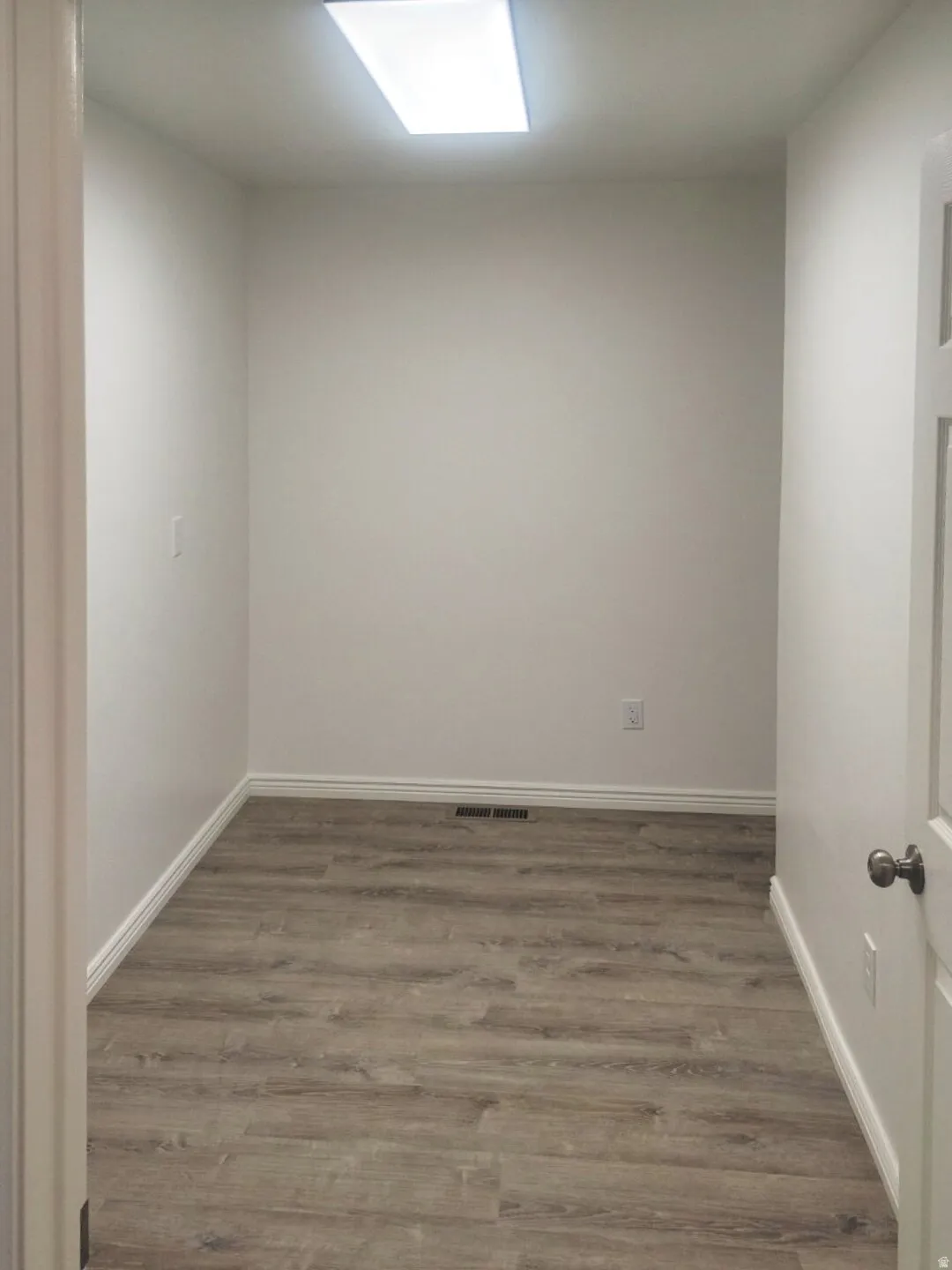 Interior room featuring wood-finish flooring and a rectangular ceiling light fixture