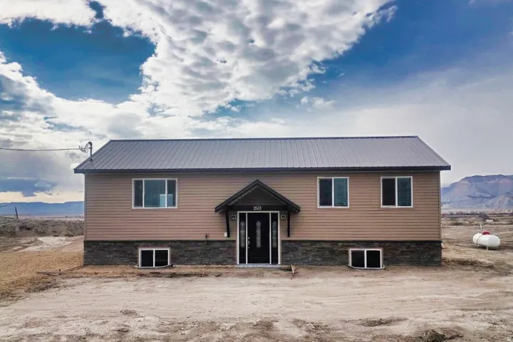 Two-story residence featuring light brown horizontal siding and a dark gray metal roof