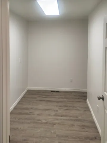 Interior room featuring wood-finish flooring and a rectangular ceiling light fixture