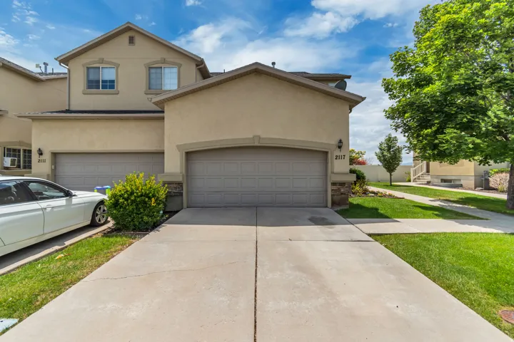 Stucco exterior residence featuring an attached garage and concrete driveway