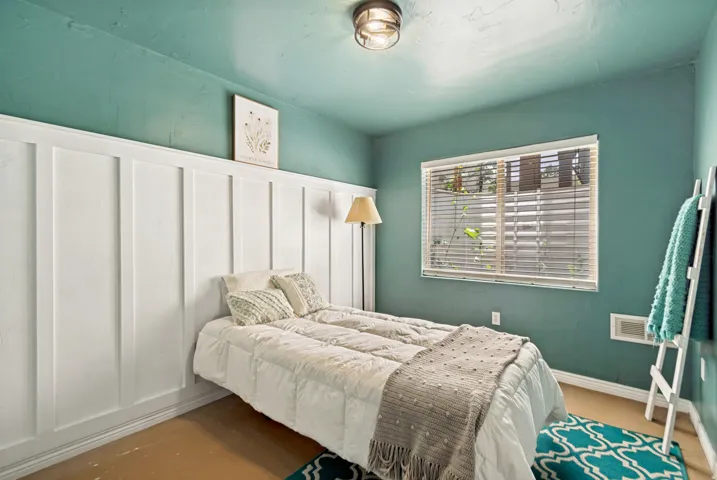 Interior space featuring board and batten wall paneling, a ceiling-mounted light fixture, a window with horizontal blinds, and solid-color walls