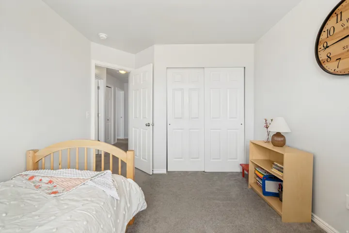 Room with neutral wall paint, gray carpet, and a white sliding closet door