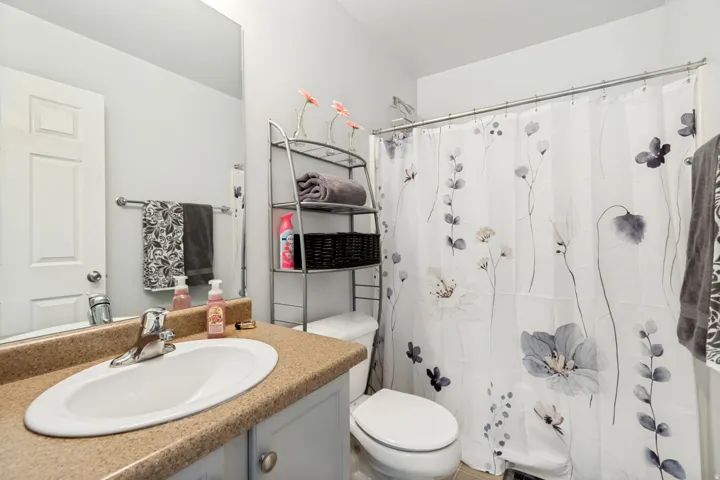 Bathroom featuring a vanity with an integrated oval sink, a light-colored countertop, and a chrome faucet
