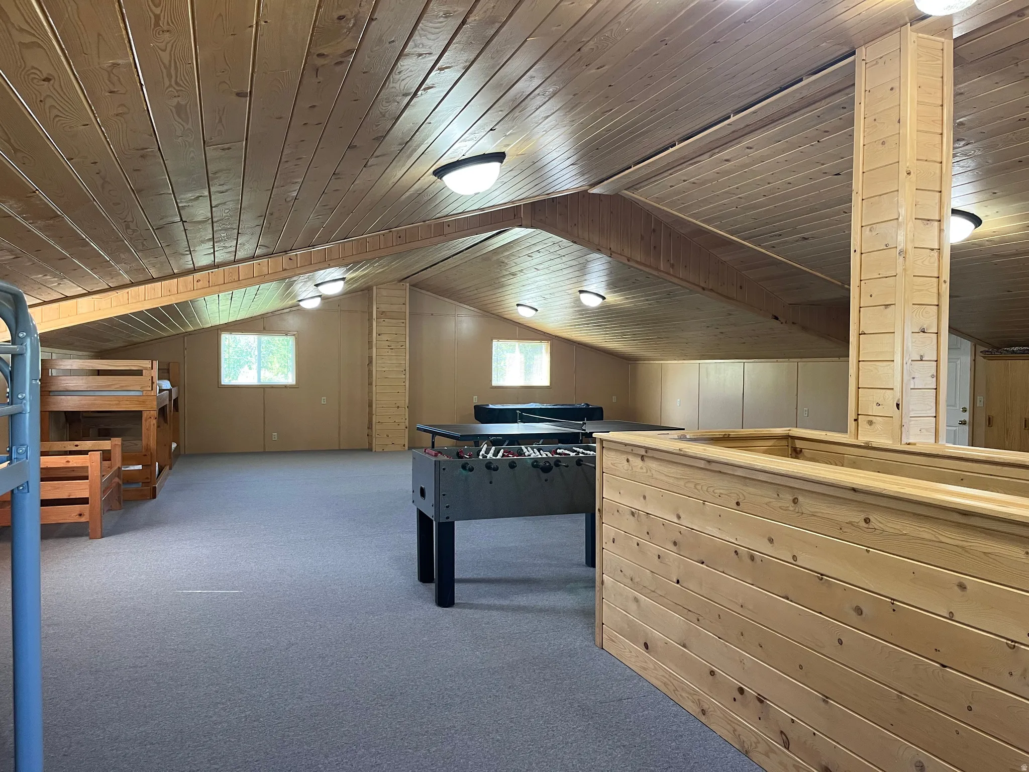 Spacious loft area featuring wood-finish vaulted ceilings, recessed lighting, and light-colored carpeting