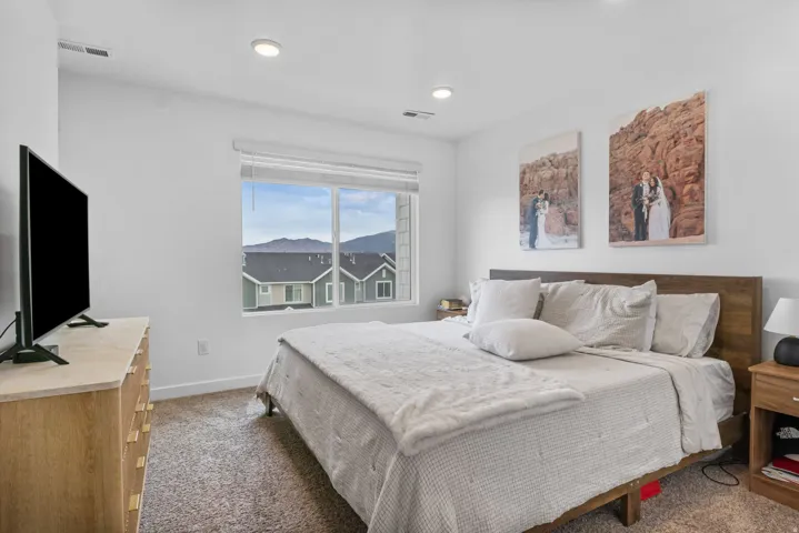 Bedroom featuring neutral wall paint, recessed lighting, and a window with mountain scenery