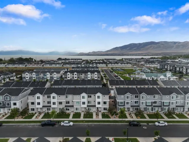 Aerial perspective showcasing a community of townhomes with dark gray roofs and light-toned siding