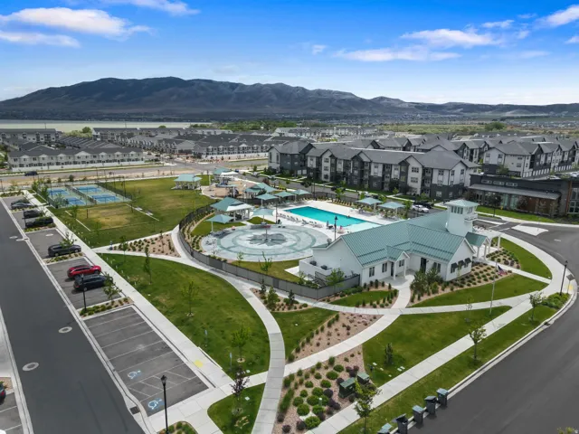 Community clubhouse featuring a swimming pool, splash pad, and surrounding green spaces