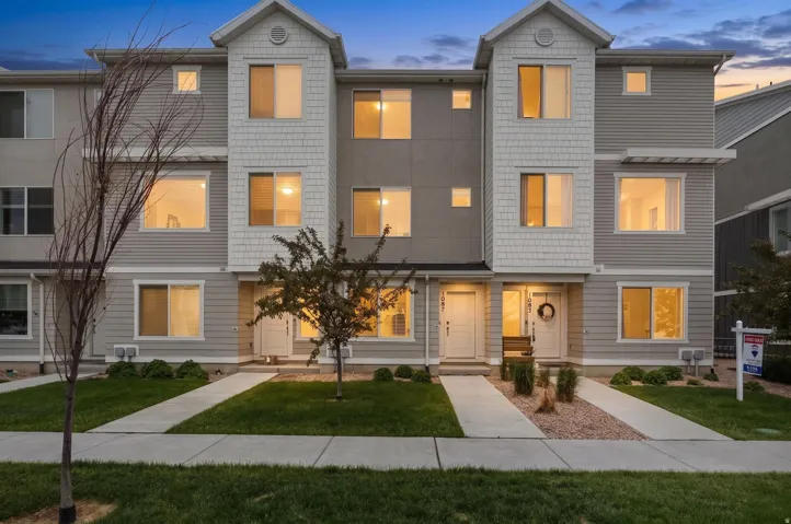 Contemporary townhome exterior featuring multi-textured siding, gabled rooflines, and multiple window placements