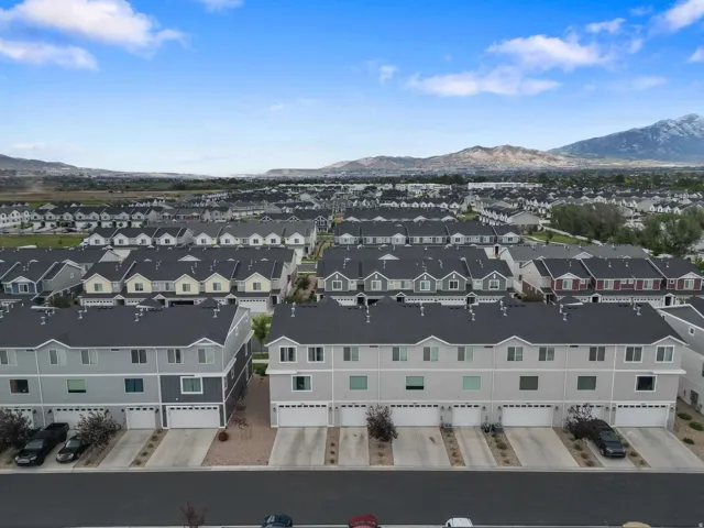 Aerial perspective showcasing a residential community with multi-story townhomes, each featuring a private garage